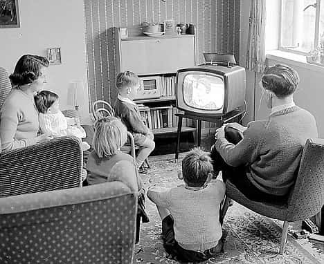 Zwart wit, gezin jaren 50 kijkt tv